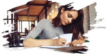 girl sitting at desk writing on paper