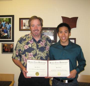 Two people holding a certificate titled