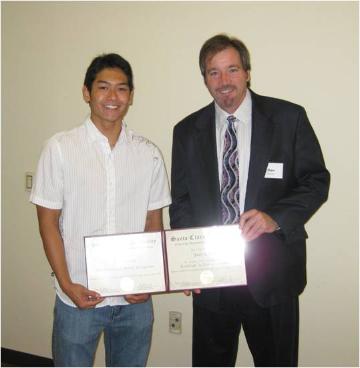 Two individuals holding certificates and standing side by side.