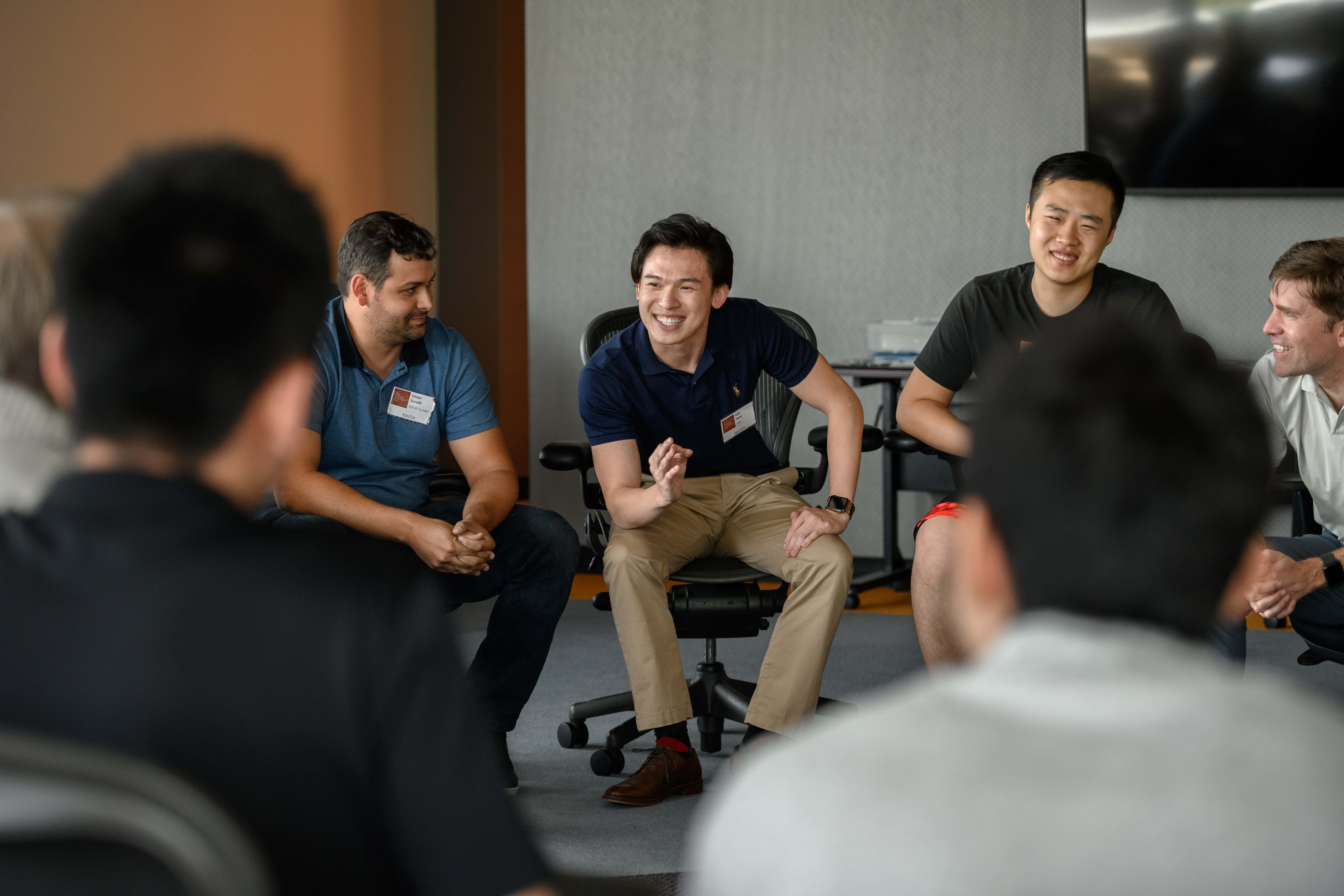 A small group of people having a discussion. - Student in group Link to file