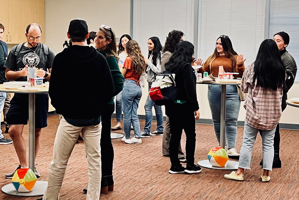 People socializing and eating at the Ciocca Center Beach Day event.