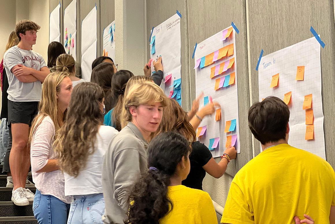 People interacting with posters at Ciocca Center Idea Lab event, Fall 2022.