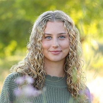 Woman smiling in green shirt outdoors