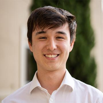 Man in white shirt outdoors smiling