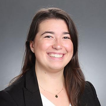Woman in black blazer and white top smiling