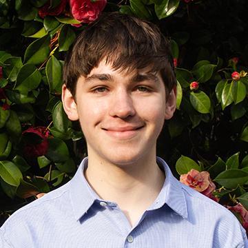 Man smiling in blue shirt outdoors