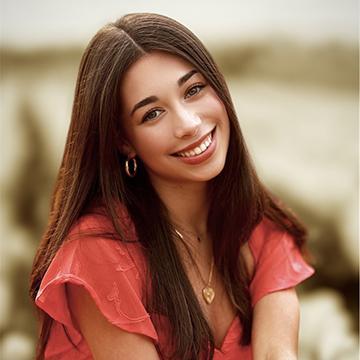Woman outdoors in red top smiling