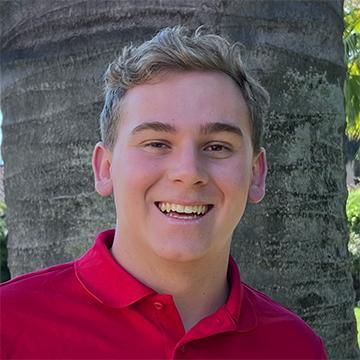 Man in red shirt outdoors smiling
