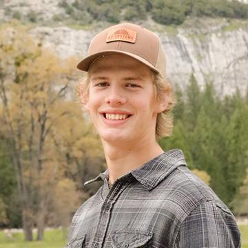 Man in baseball cap smiling outdoors