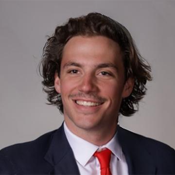 Man in suit and red tie smiling