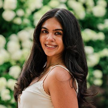 Woman in white top outdoors smiling