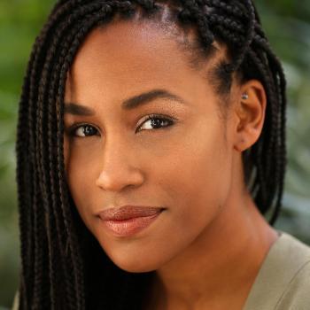 Portrait of Malarie Howard with greenery in the background.