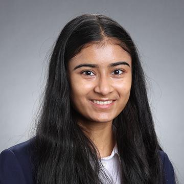 Woman in black blazer and white shirt smiling