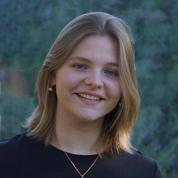 Woman in black shirt outdoors smiling