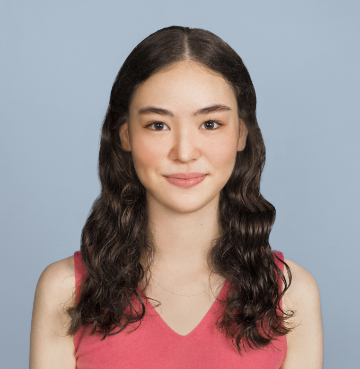 A person with a pink top against a blue background.