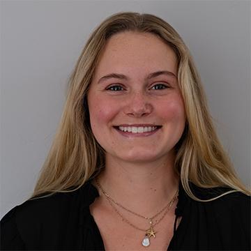 Woman with long hair smiling wearing a black top