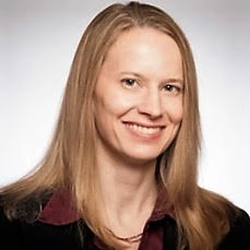 A person smiling with a light background.