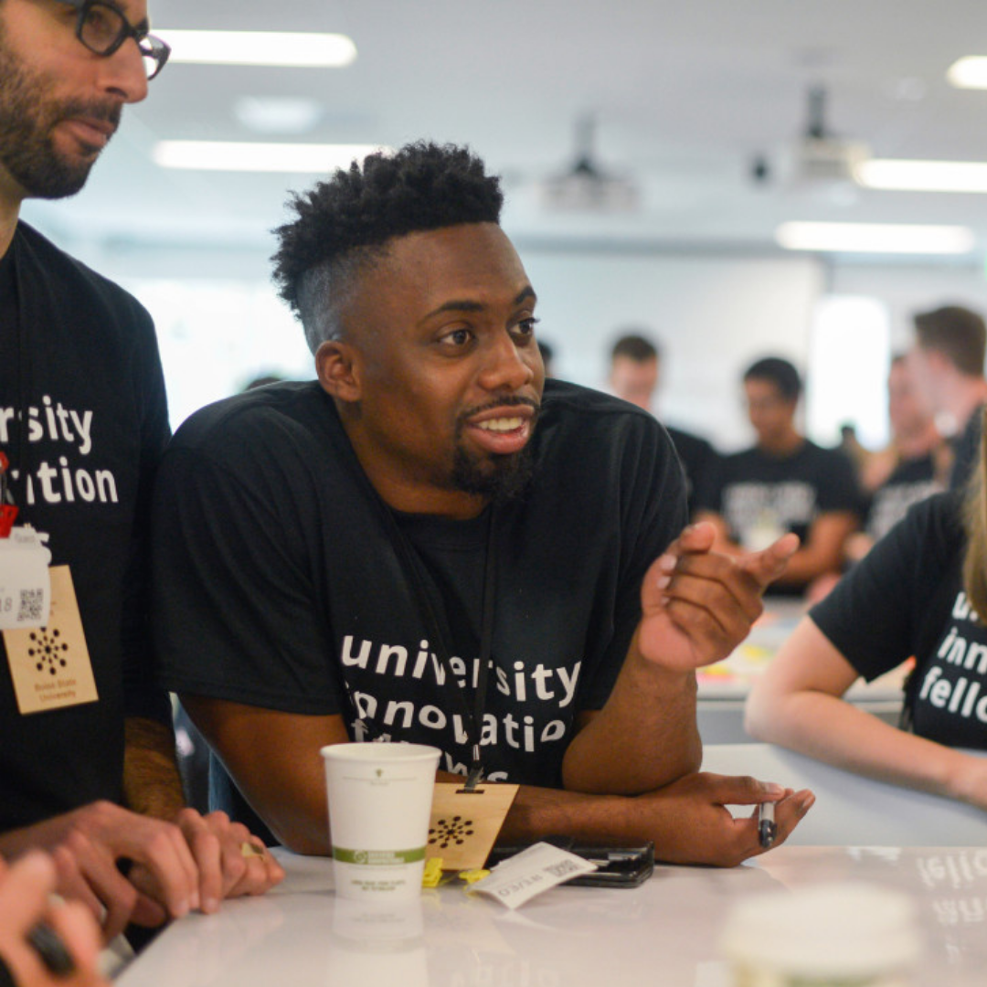 A group of people engaging in conversation while wearing black shirts.