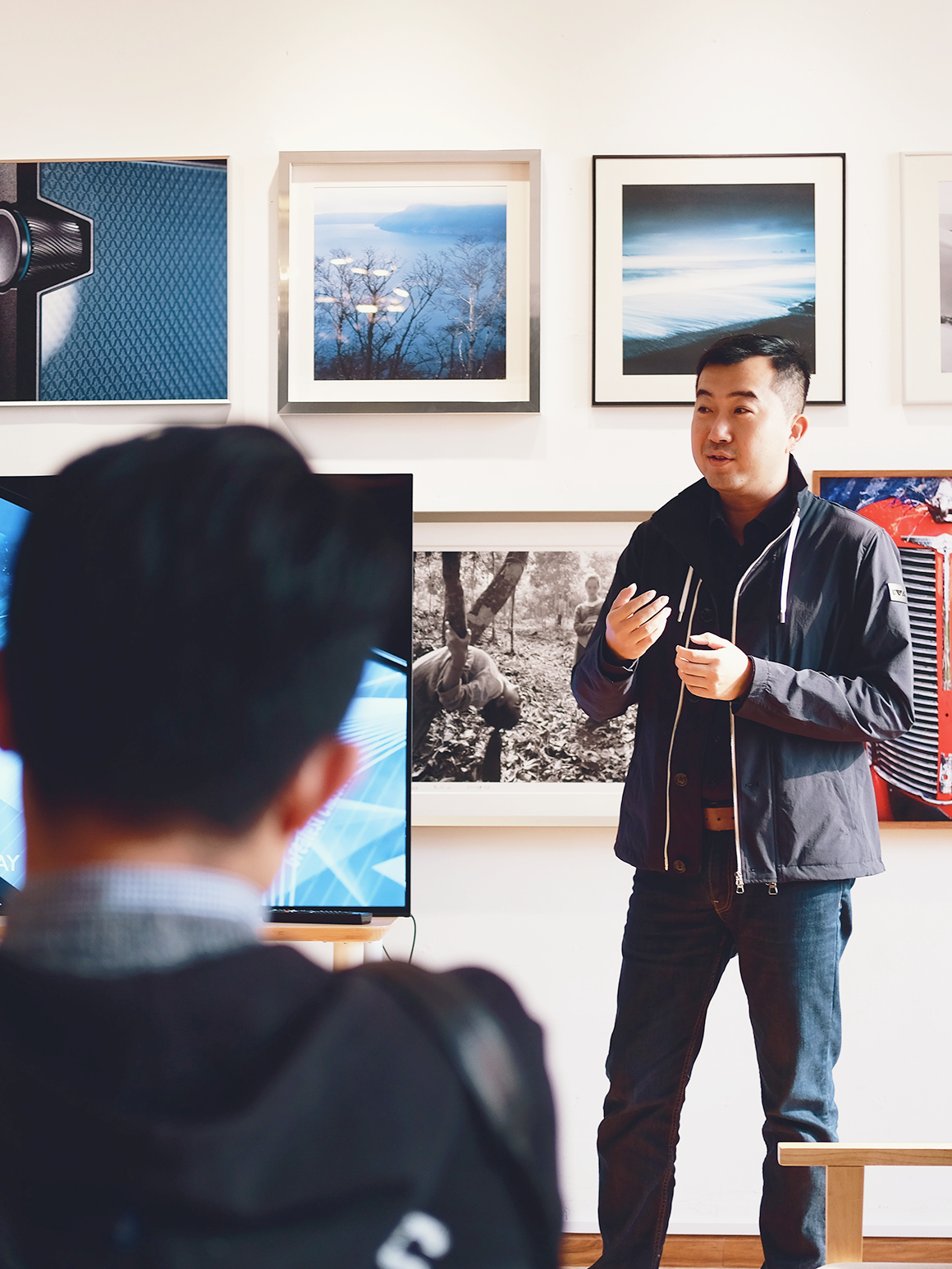 Man giving presentation in front of flatscreen tv
