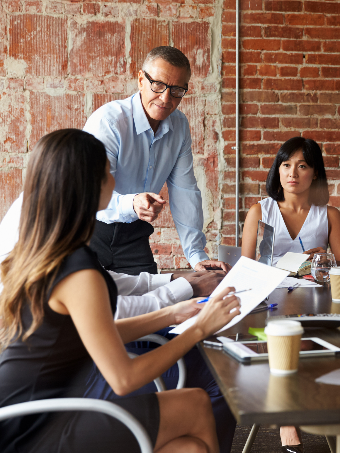 Man at table with two women, business meeting