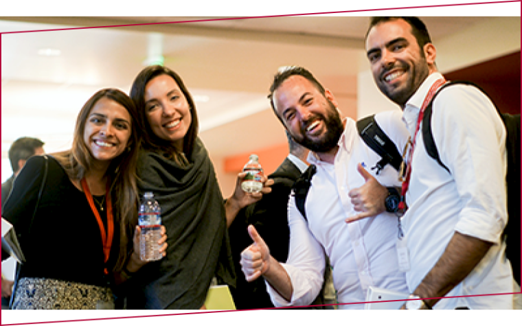 Custom program participants, two female and two male, standing and smiling at the camera