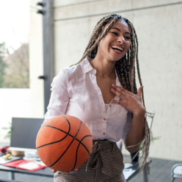 A cheerful young businesswoman having fun with ball in office take a break