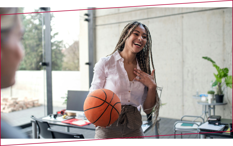 A cheerful young businesswoman having fun with ball in office take a break
