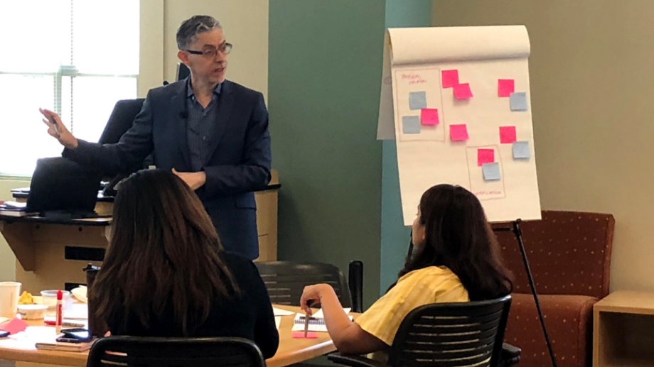Pierre Khawand stands next to large post it note board