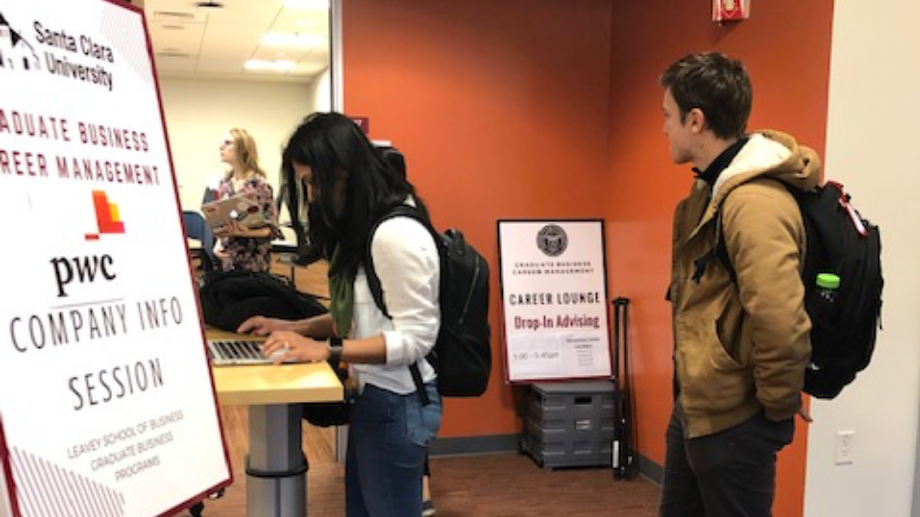 Two students signing in for the PwC Information session
