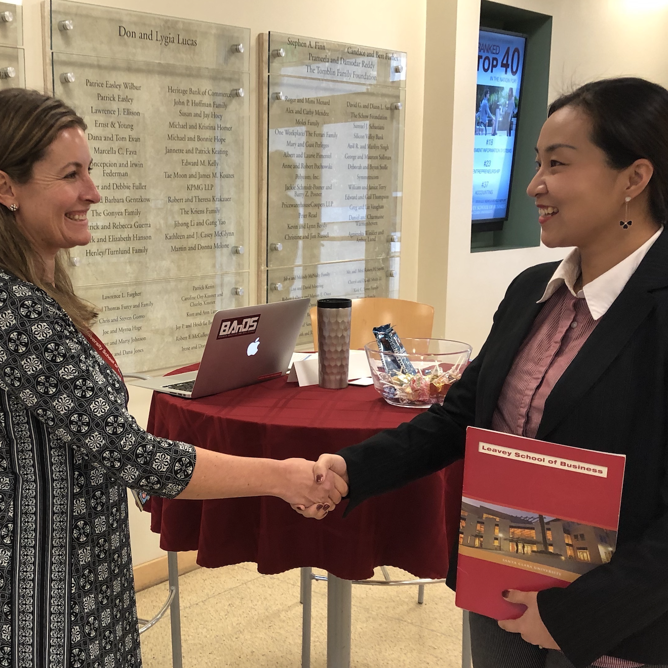 A student in a career fair shaking hands with an employer 
