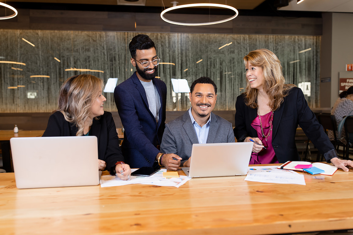 Students conversing over laptop in Benson