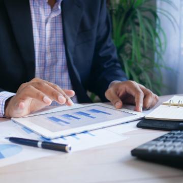 person in black suit jacket holding white tablet computer
