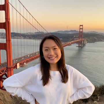 A person standing in front of the Golden Gate Bridge.