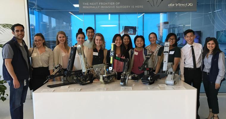 A group of people posed together indoors around a table.