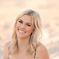 A person sitting outdoors in a patterned jumpsuit.