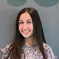 A person stands in front of a wall with a 