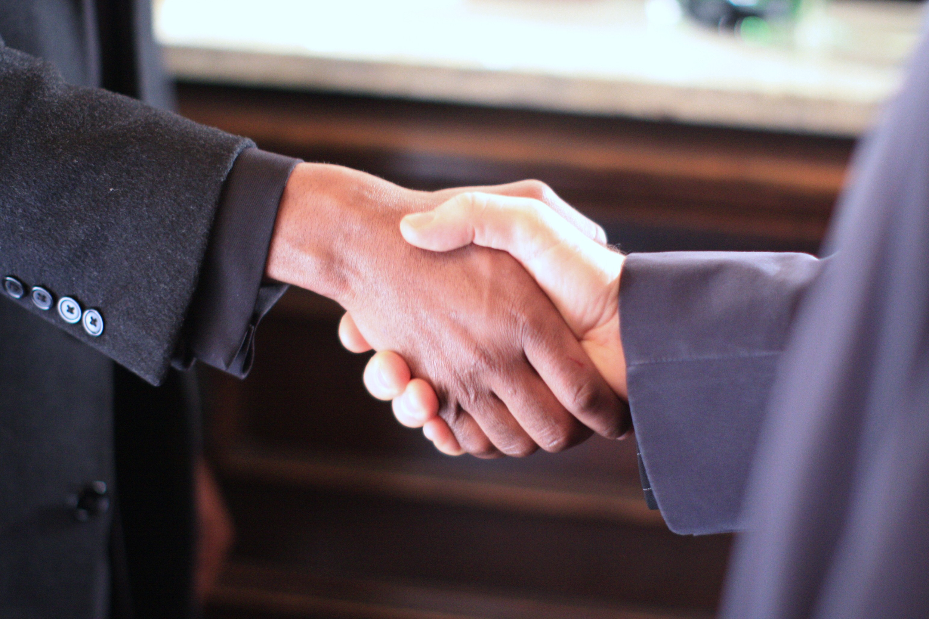 Two individuals shaking hands in a professional setting.