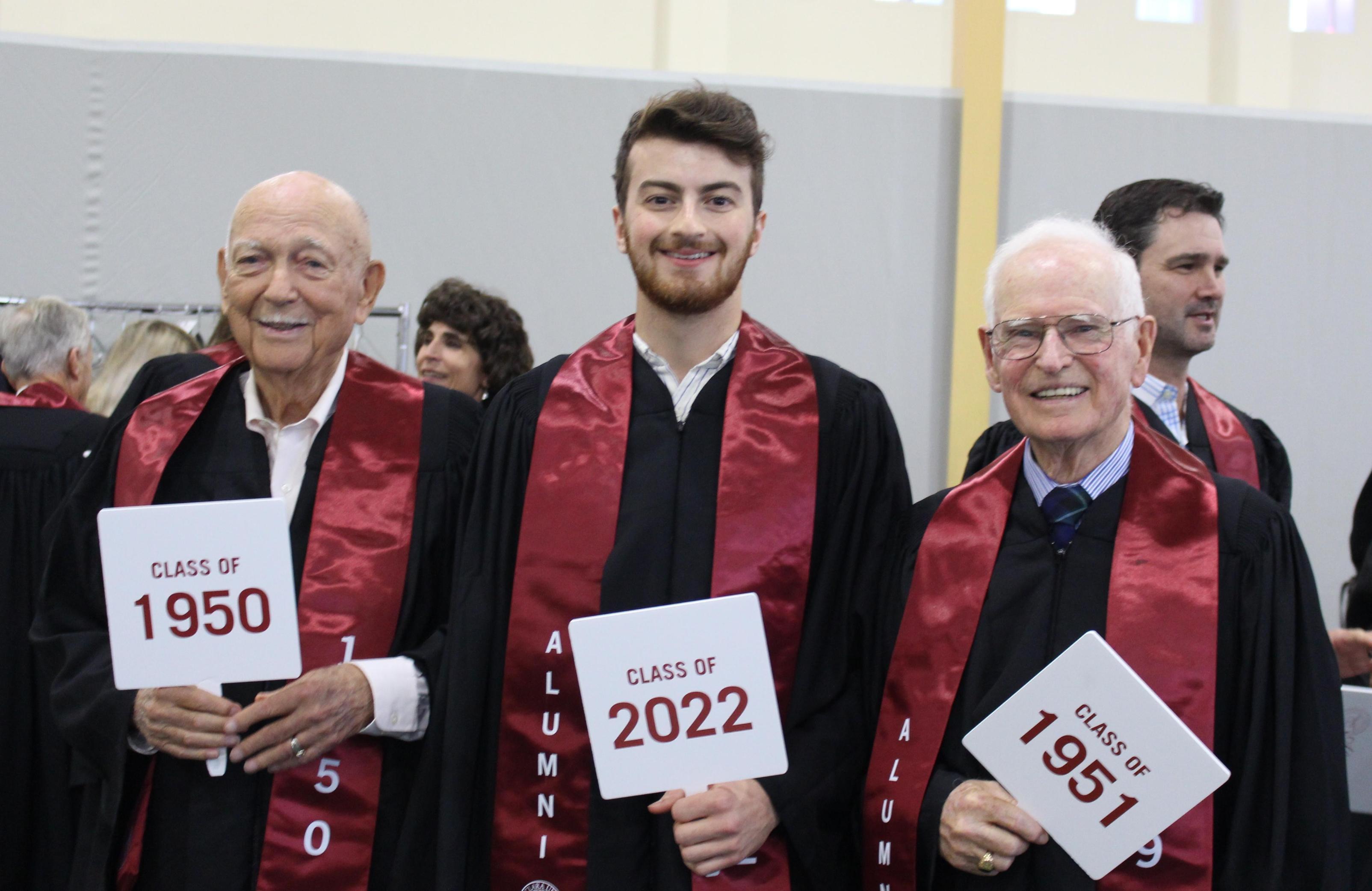 A group of people in robes holding pamphlets at an event.
