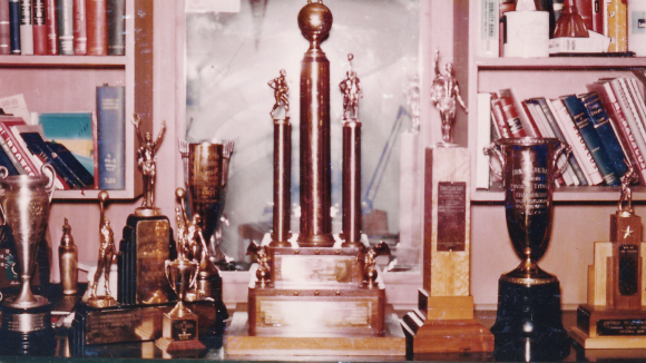 A vintage photo from c.1957 of several USF sports trophies on a bookshelf