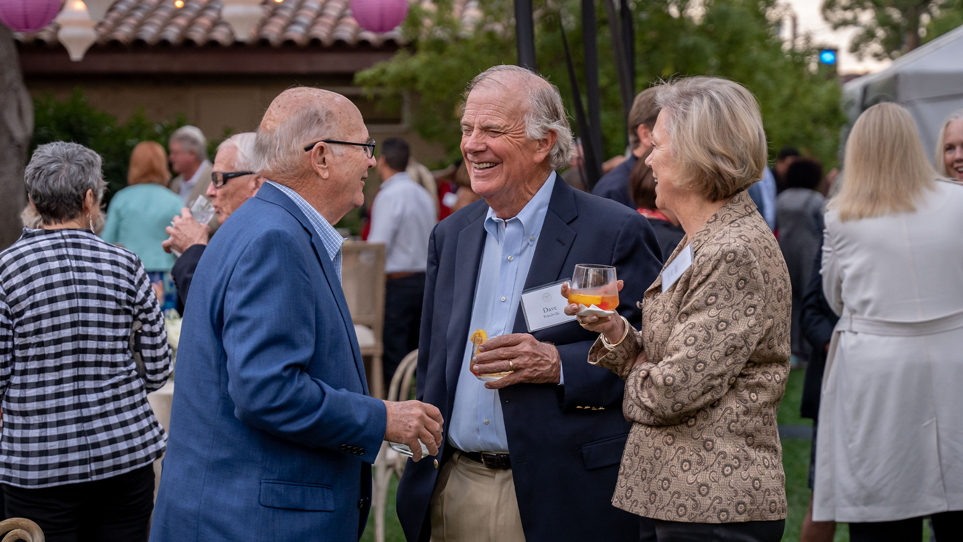 Group of alumni talking in the mission gardens