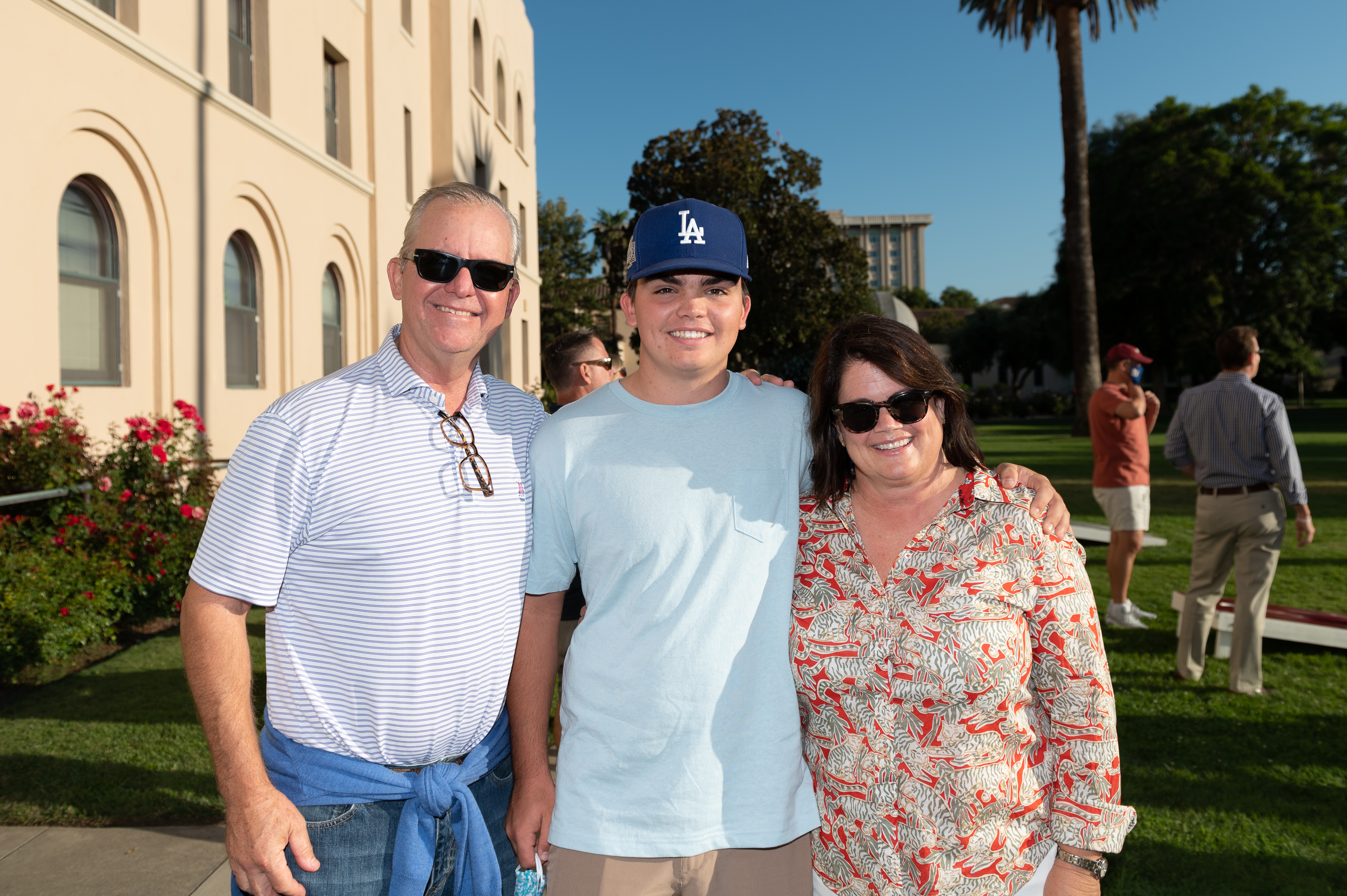 Three people posing outside at Legacy BBQ event.