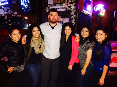 Group of people posing together at a nighttime venue.
