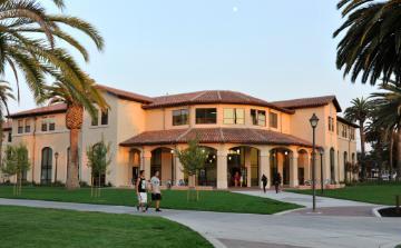 Graham Residence Hall building with palm trees and a grassy area.