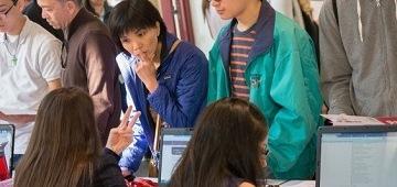 People interacting at an information desk.