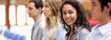 A group of people smiling and socializing outdoors.