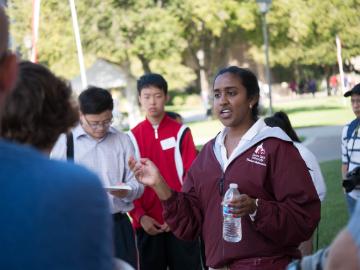 A group of people conversing outside on a sunny day.