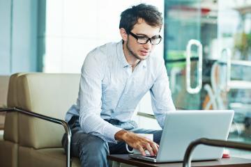 Man working on a laptop in a modern office.