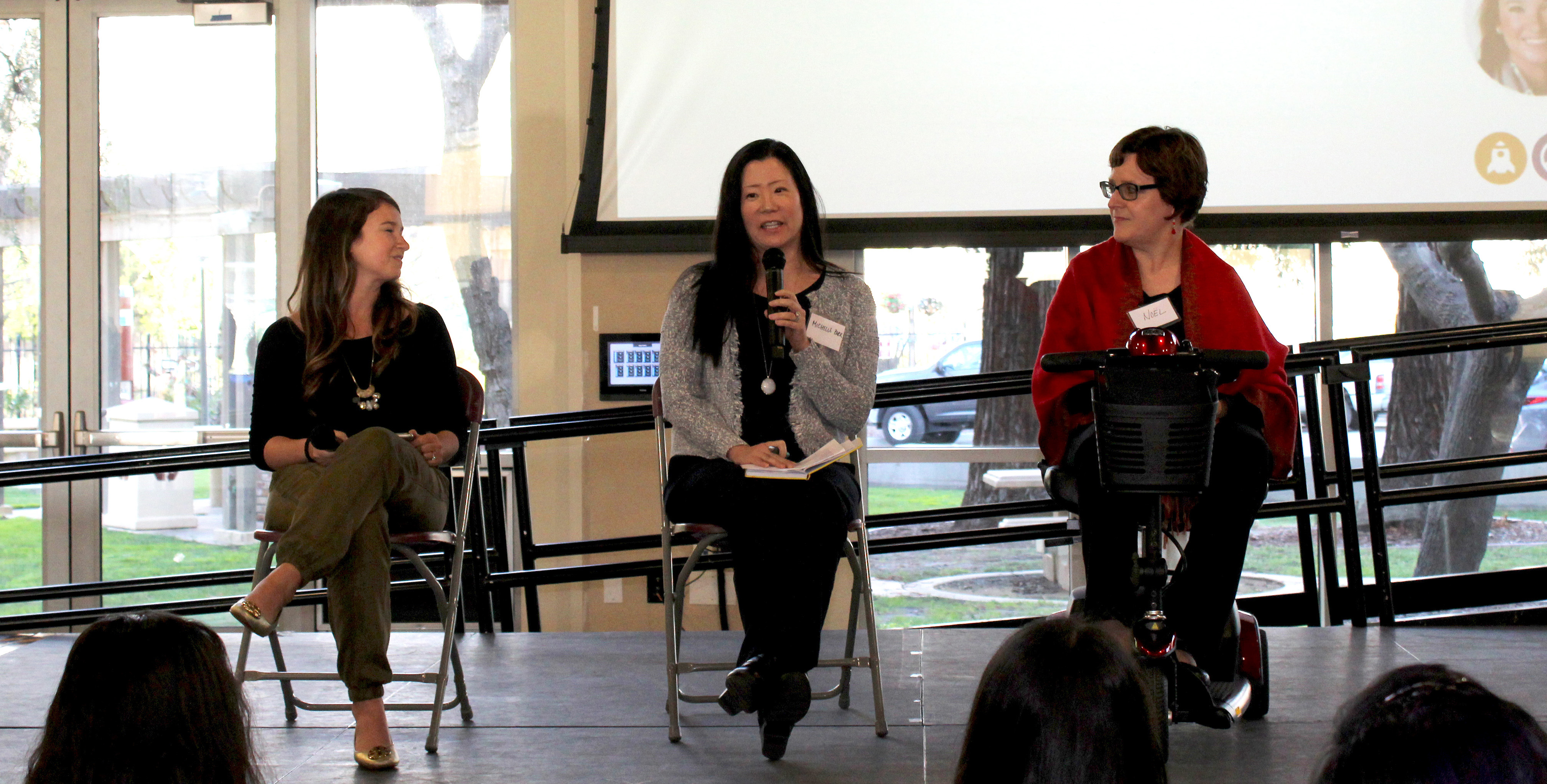 Alt text: Three people sitting on stage at Diversity Works Expo 2019 panel discussion.