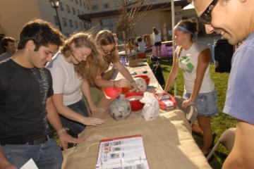 Students gathered around a table with various items at Santa Clara University.
