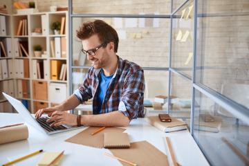 A person working on a laptop at a desk.